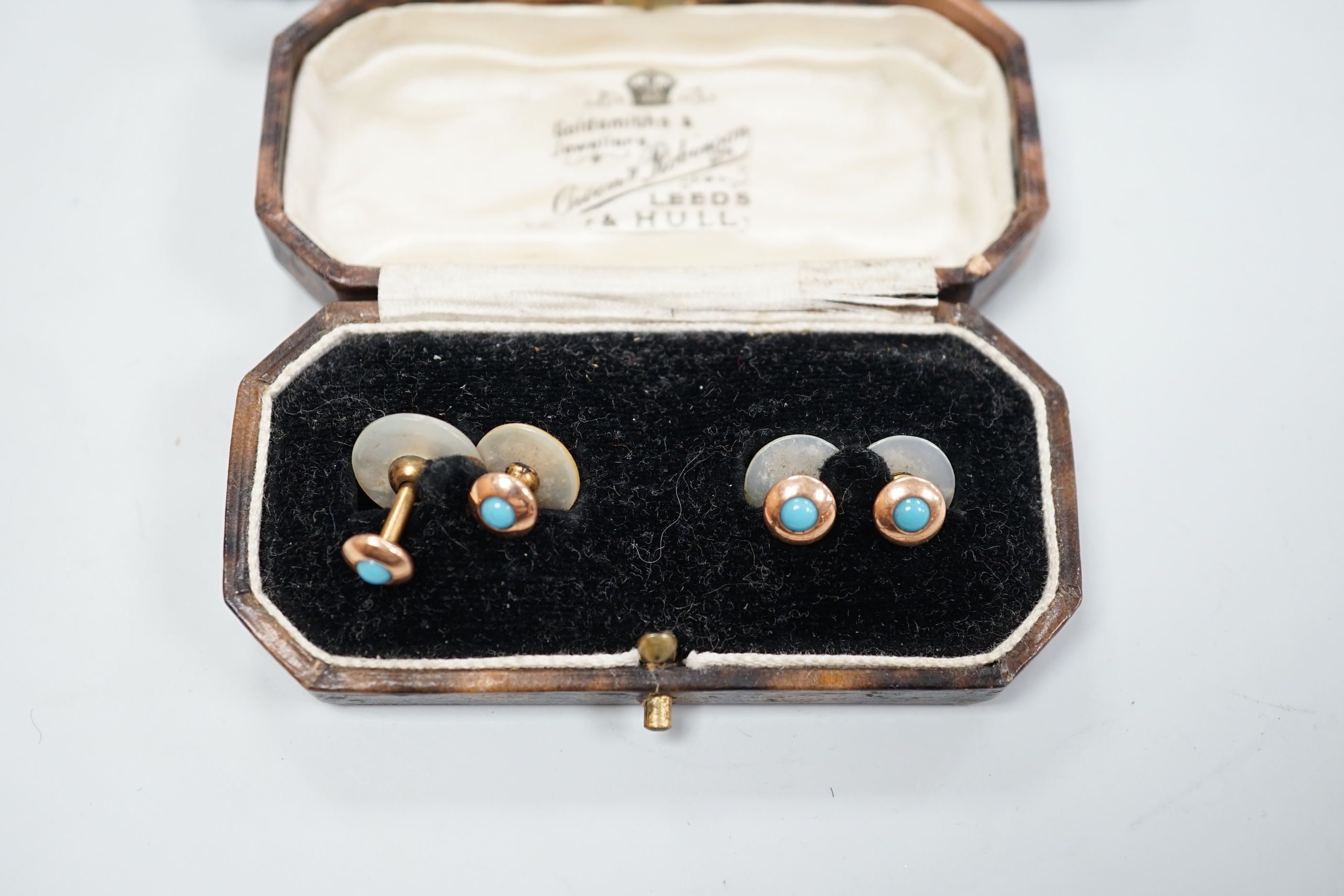 A cased set of six white metal and enamel dress studs and four other dress studs.